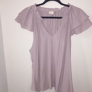Lavender blouse with shoulder ruffles.